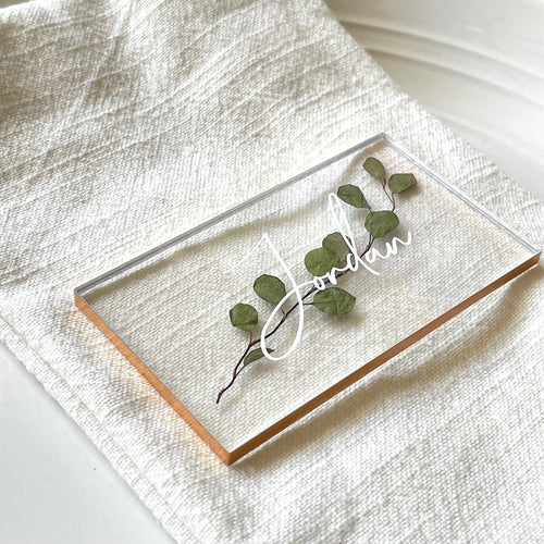 pressed eucalyptus in an acrylic wedding place card and a customized name