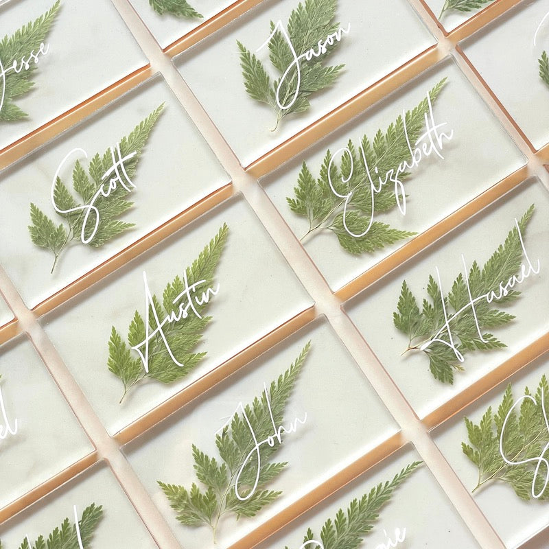 numerous pressed fern wedding place cards with gold lining