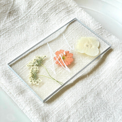 pressed peach verbena flower wedding place card closeup on napkin